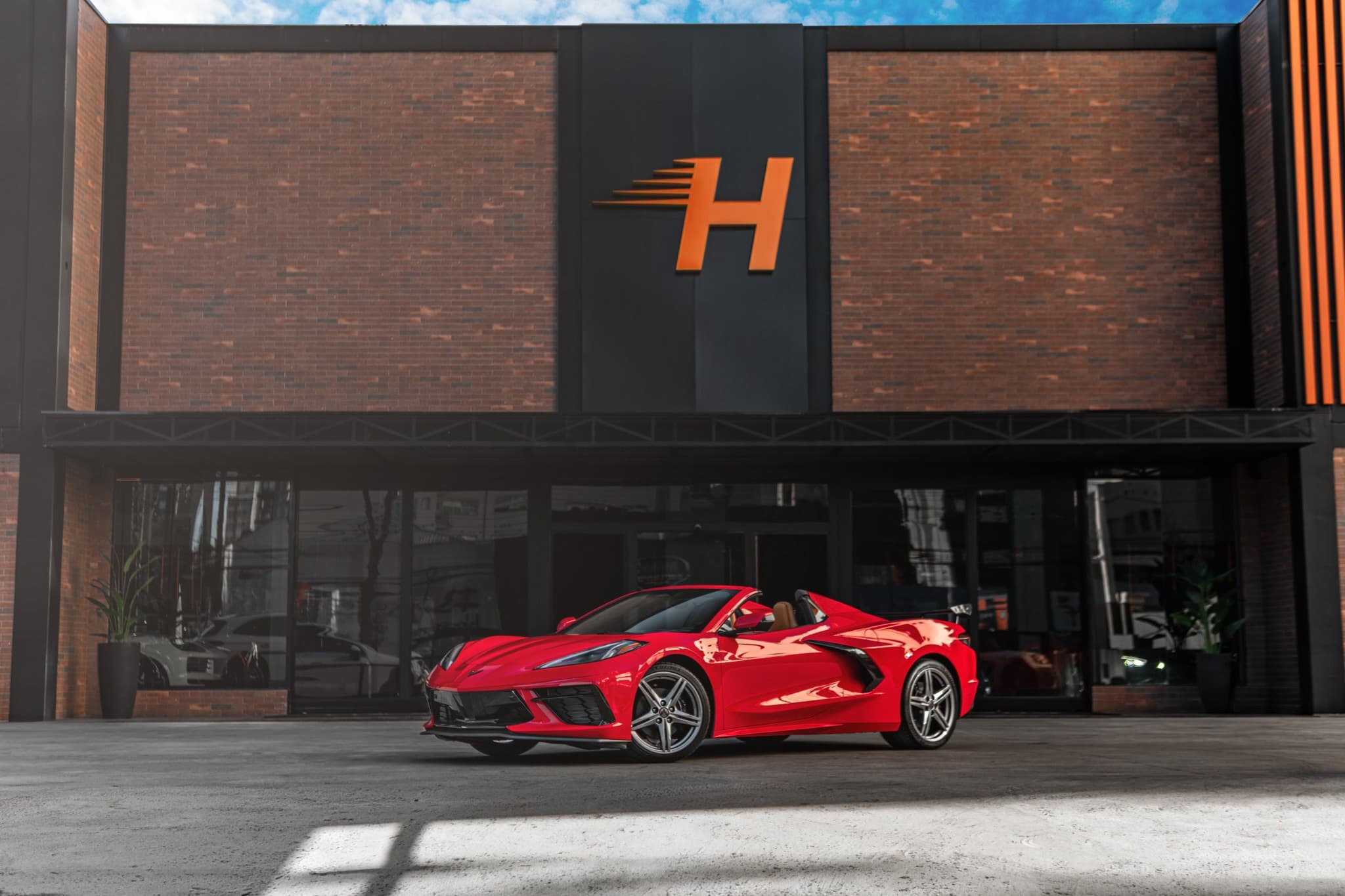 Showroom da Via Soho Motors com um Corvette vermelho